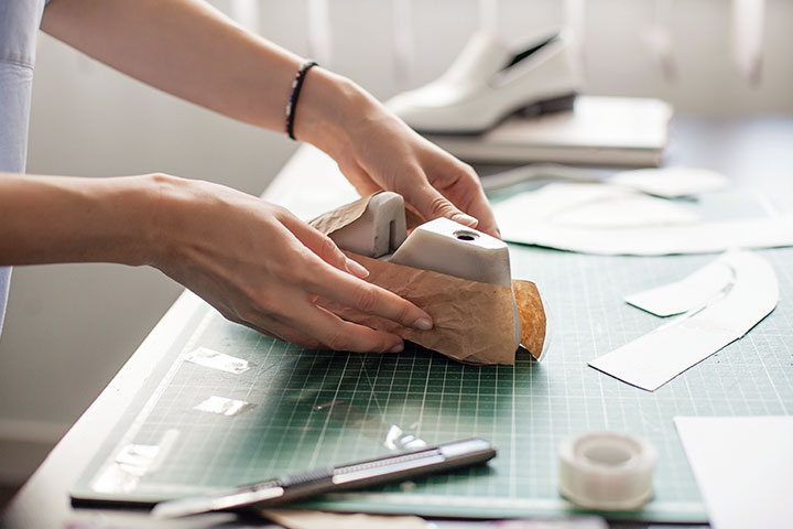 An employee using shoe lasts to make samples.